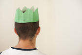 a man wearing a paper party hat from a christmas cracker