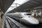 Shinkansen bullet train, or high speed tain, pulled up at a platform in a Japanese railway station