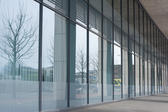 Modern building foyer with a glass walled front giving a view onto an urban forecourt and with a large empty internal space