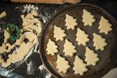 High angle view of cookies or biscuits in the shape of traditional Christmas trees arranged on a baking tray for cooking during Xmas baking