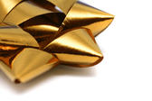 Close up of an ornate metallic gold bow used as a decoration during gift-wrapping and packaging of Christmas gifts or presents for a special occasion