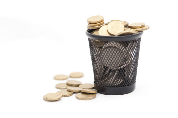 Trash bin with gold coins isolated on white background