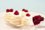 stock image Individual meringue raspberry pavlovas in decorative twirled meringue cases with whipped cream