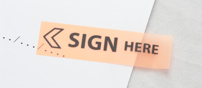 stock image a sticky marker on a contract document highlighting where the sign and date
