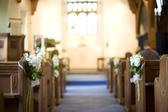 a narrow depth of field image of a church aisle decorated with white english stocks flowers