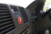 View along a car dashboard with focus to the red hazard warning button