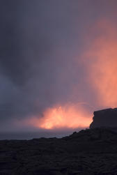 red glowing lava entering the ocean and spewing clouds of steam into the air, near Kalapana, Hawaiis Big Island 