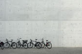 Commuter bicycles parked in a row outside a commercial building as people opt for a cheaper eco-friendly mode of transport