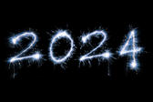 Numbers for New Year 2024 bursting out from a black background with bright sparks
