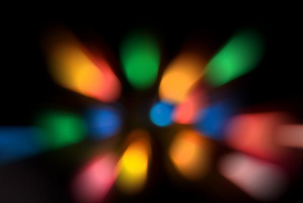 a &#039;slap zoom&#039; effect abstract background composed of out of focus coloured lights