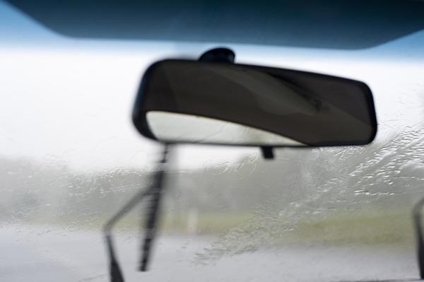 rear view mirror of a car driving on a rainy day