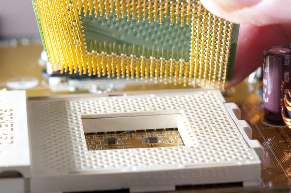 a motherboard socket and the underside of a CPU being placed