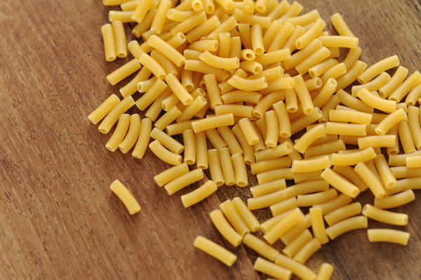 macaroni pasta tubes on a wood background
