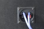 Speaker wires connected to spring loaded terminals on the back of a speaker cabinet