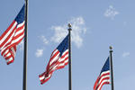 Three flagpoles flying the Stars and Stripes, the official national flag of the United States Of America.
