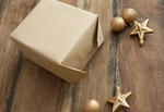 a partly wrapped christmas gift in plain brown paper