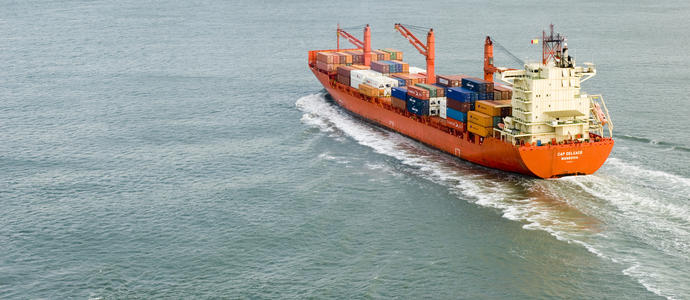 stock image A large cargo ship full of shipping containers sailing into port