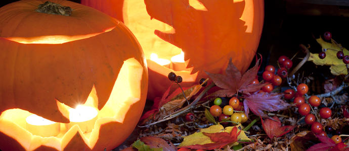 two carved halloween pumpkin lantern and a wreath of seasonal autumn berries and leaves